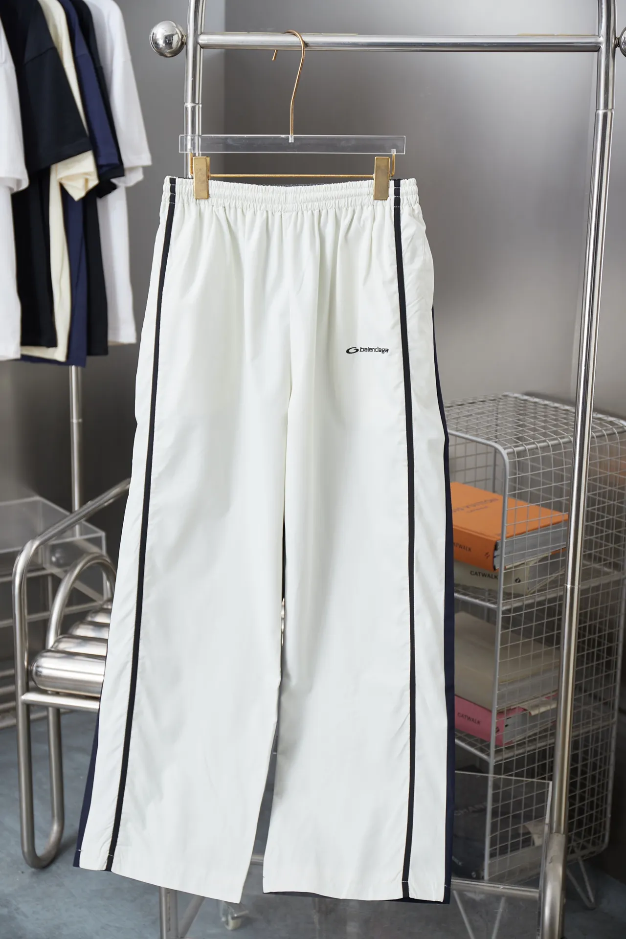 Balenciaga 𝘽𝘼𝙇𝙀𝙉𝘾𝙄𝘼𝙂𝘼 BLCG 25SS double-split waterproof sports pants. Light luxury. A must-have item for daily commuting for men and women. Correct version. Welcome to compare. Detailed features · Customized matt Taslan jacket fabric · The entire fabric is pre-treated with a waterproof coating · The interior is made of three-level polyester bird's eye mesh · OS ultra-loose silhouette design · Side pockets · Elastic waistband design · Contrast color Black webbing splicing · Front and rear contrast color splicing and cutting design · Imported Tajima machine embroidery ring logo · Original main mark washed tag brand packaging Color: White/Royal Blue Size: 46/48/50/52